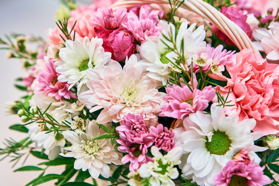 Nahaufnahme eines bunten Blumenstraußes Nahaufnahme eines bunten Blumenstraußes mit weißen, rosa und pinken Blüten in einem Flechtkorb.